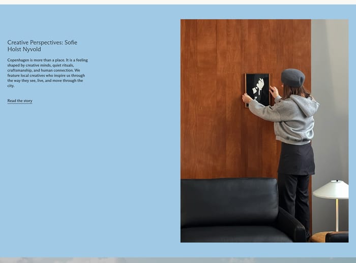 Jakobsen Copenhagen interview section with blue copy panel and photo of a woman hanging art above a sofa