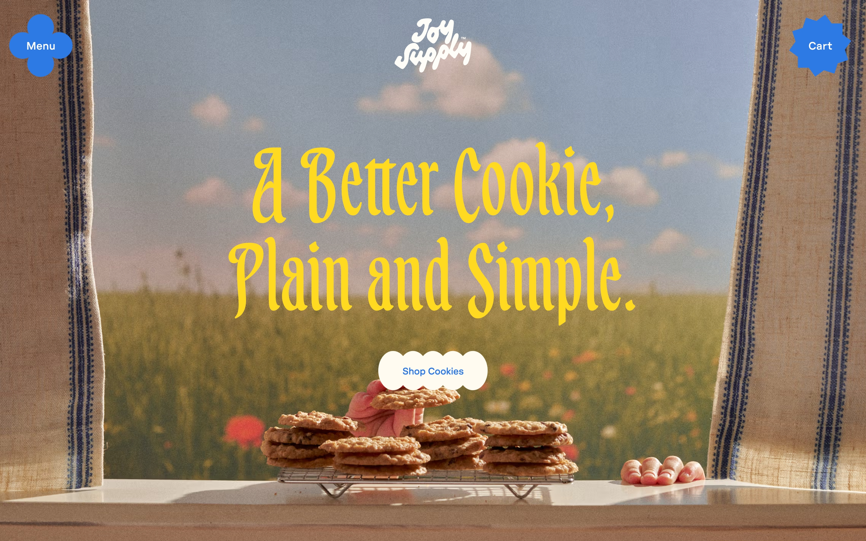 Joy Supply hero: yellow cookie headline over a farm window, sill cookies, Menu, Cart, and Shop Cookies.