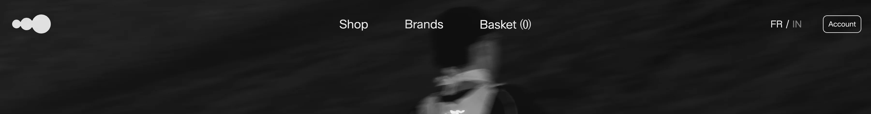 Apt Curation header with white logo, Shop Brands Basket, FR/IN and Account over a dark blurred figure