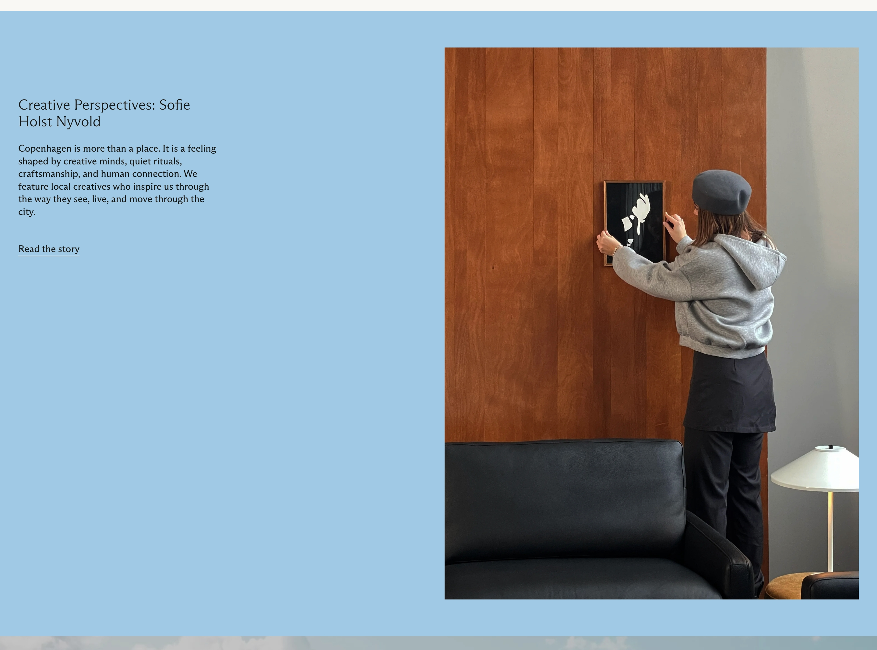 Jakobsen Copenhagen interview section with blue copy panel and photo of a woman hanging art above a sofa