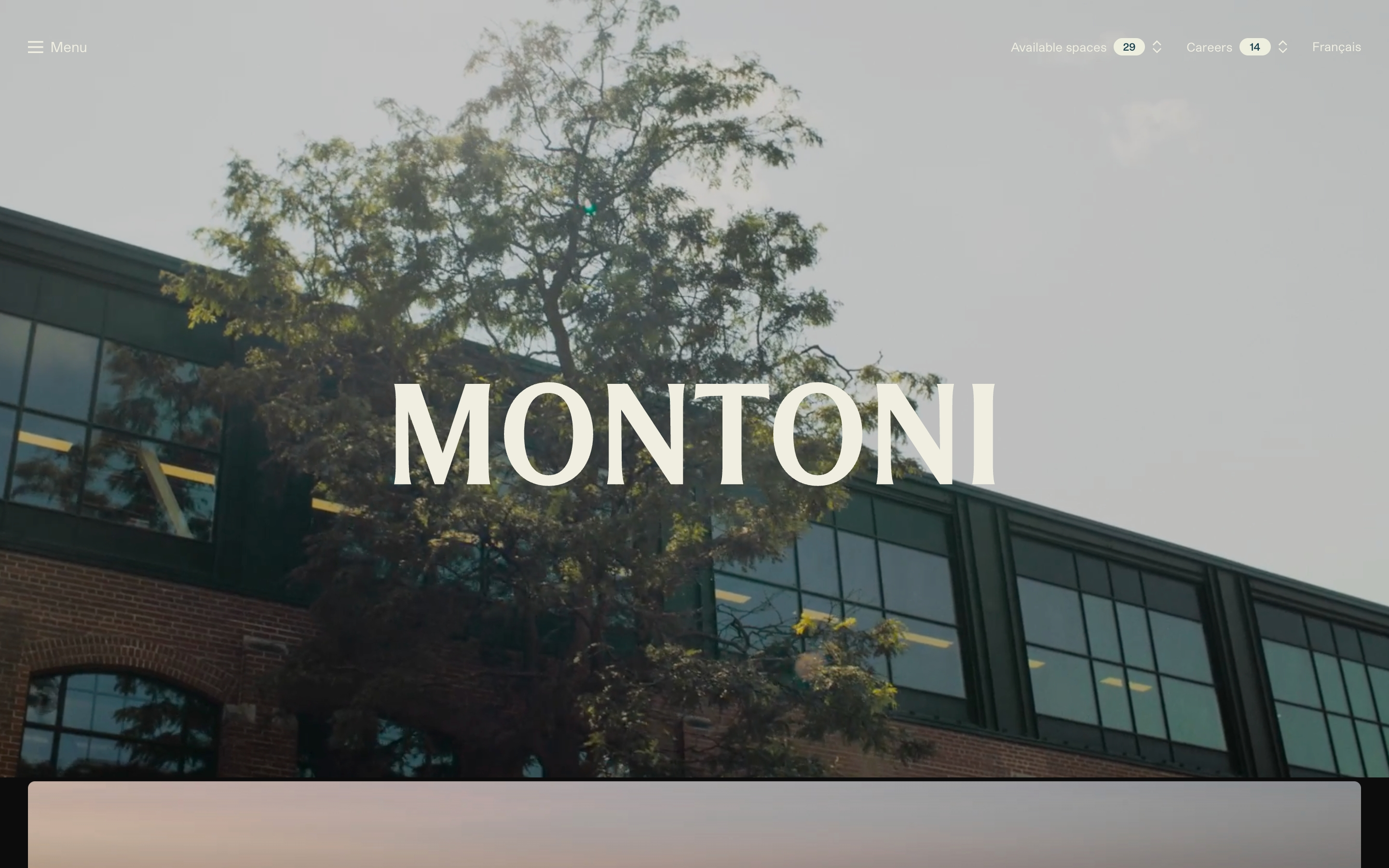 Montoni hero: oversized cream MONTONI wordmark centered over a brick-and-glass building and tree photo.